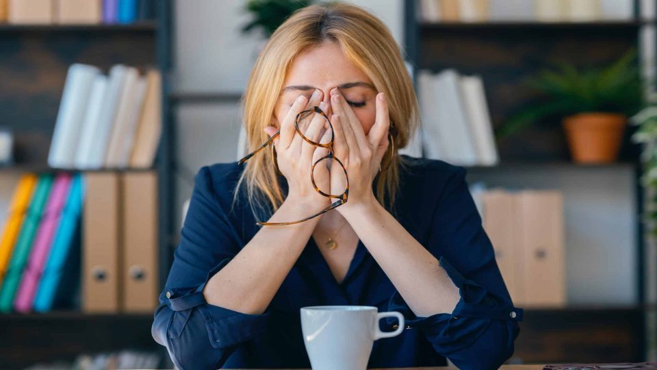 Focused Woman in Office Contemplating with Eyes Closed During a Break