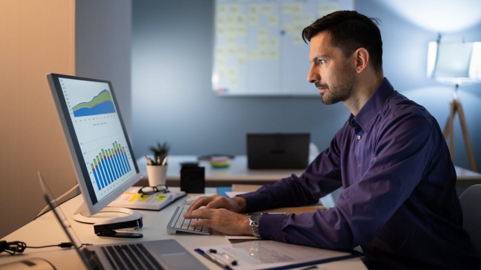 Mid Adult Businessman Working Late At Desk In Office