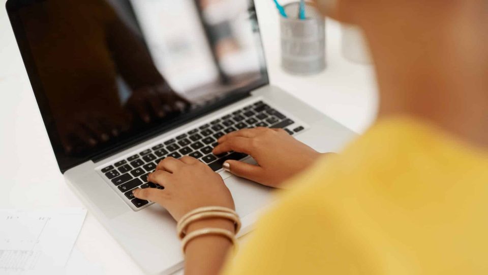 Screen, writer or hands of woman on laptop in office for research, editing and creative media agency. Books, news story or journalist with technology for publication website, startup and blog update.